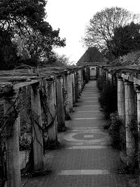 Empty footpath amidst buildings against sky