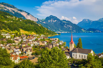 Trees and townscape by mountains against sky