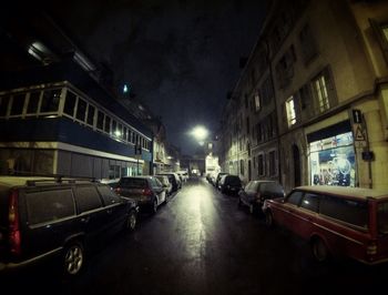 Road passing through illuminated city at night