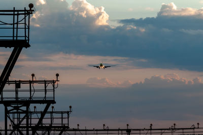 Low angle view of airplane flying against sky during sunset