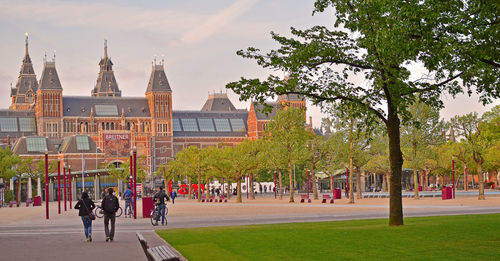 Rear view of people walking on city street