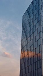 Low angle view of modern building with glas against sky