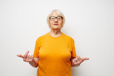 Portrait of young woman standing against white background