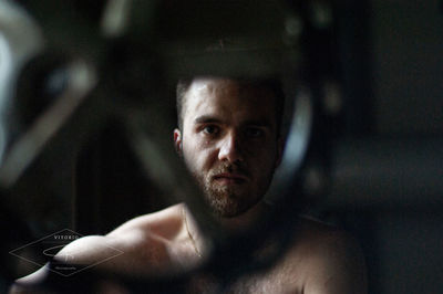 Portrait of young man seen through hole in metal