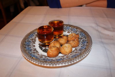 Whiskey and food in plate on restaurant table