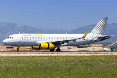 Airplane on airport runway against sky