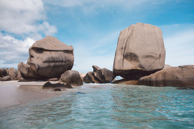 Rocks on sea shore against sky