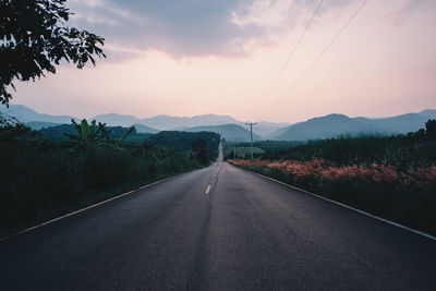 Empty road against sky during sunset