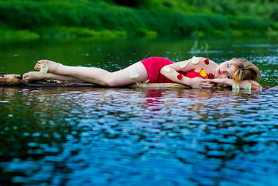 Young woman sleeping in river 