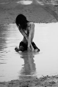 Rear view of woman sitting in water