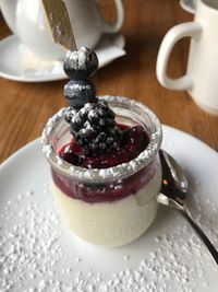Close-up of panna cotta served in glass container on table