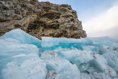 Scenic view of glacier by sea against sky