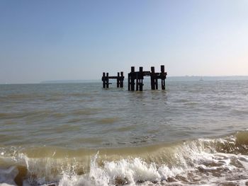 Scenic view of abandoned pier in calm sea against clear sky