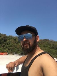 Portrait of man in sunglasses against clear blue sky