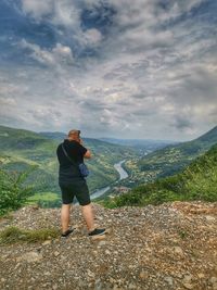 Woman standing on mountain against sky