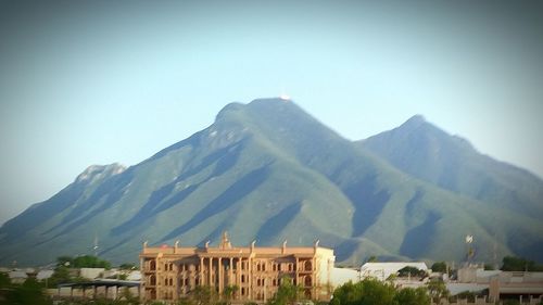 Houses against mountains against clear sky