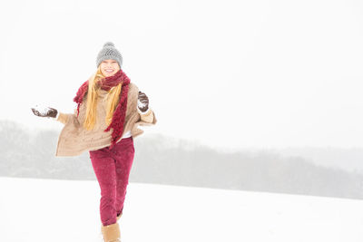 Portrait of smiling woman standing on snow