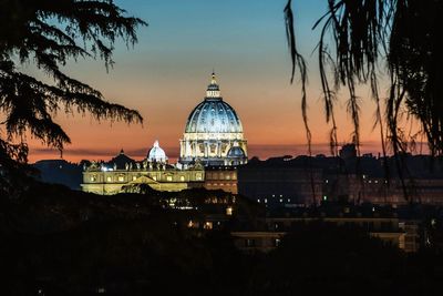 View of illuminated buildings in city during sunset