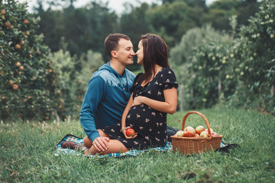 Young couple kissing in basket on field