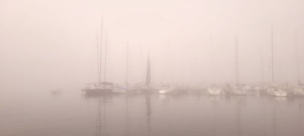 Sailboats in sea against sky