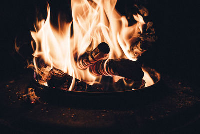 Close-up of bonfire on log at night