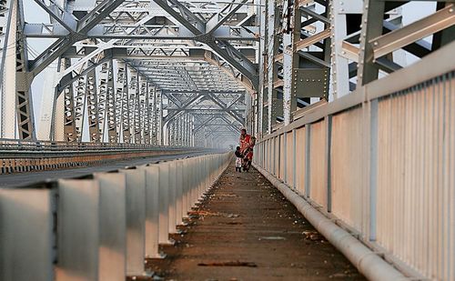 Rear view of woman walking on footbridge