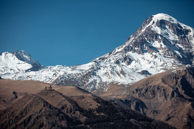 Scenic view of snowcapped mountains against clear blue sky