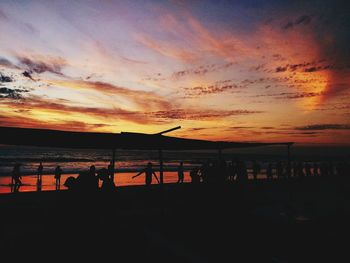 Silhouette people at beach during sunset