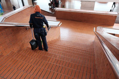 Rear view of man standing on staircase