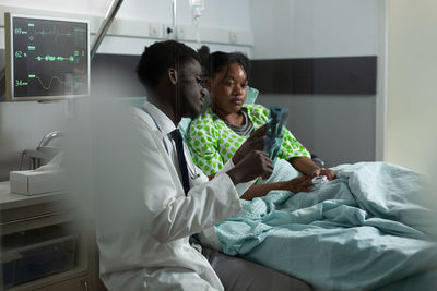 Doctor showing medical x-ray to patient in hospital