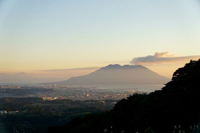 Scenic view of sea and cityscape against sky during sunset
