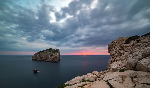 Scenic view of rock formation in sea against sky