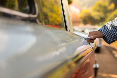 Close-up of woman opening vintage car door