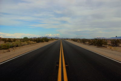 Empty road against cloudy sky