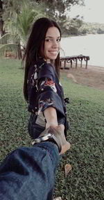 Portrait of a smiling young woman sitting on land