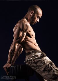 Portrait of shirtless man against black background