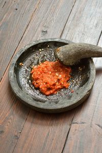 High angle view of sambal in stone mortar on table