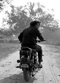 Rear view of man riding bicycle