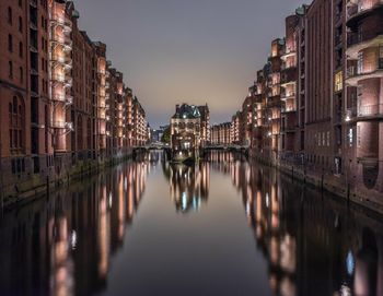 Reflection of illuminated buildings on water at dusk