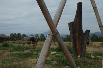 Wooden posts on field against sky