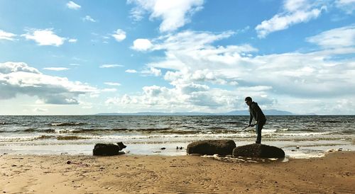 Man standing on beach against sky