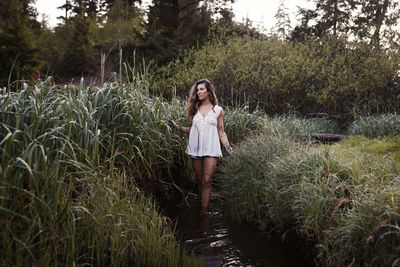 Portrait of young woman standing on grass