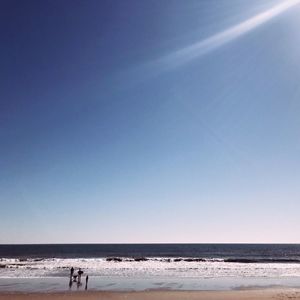 Scenic view of beach against clear blue sky