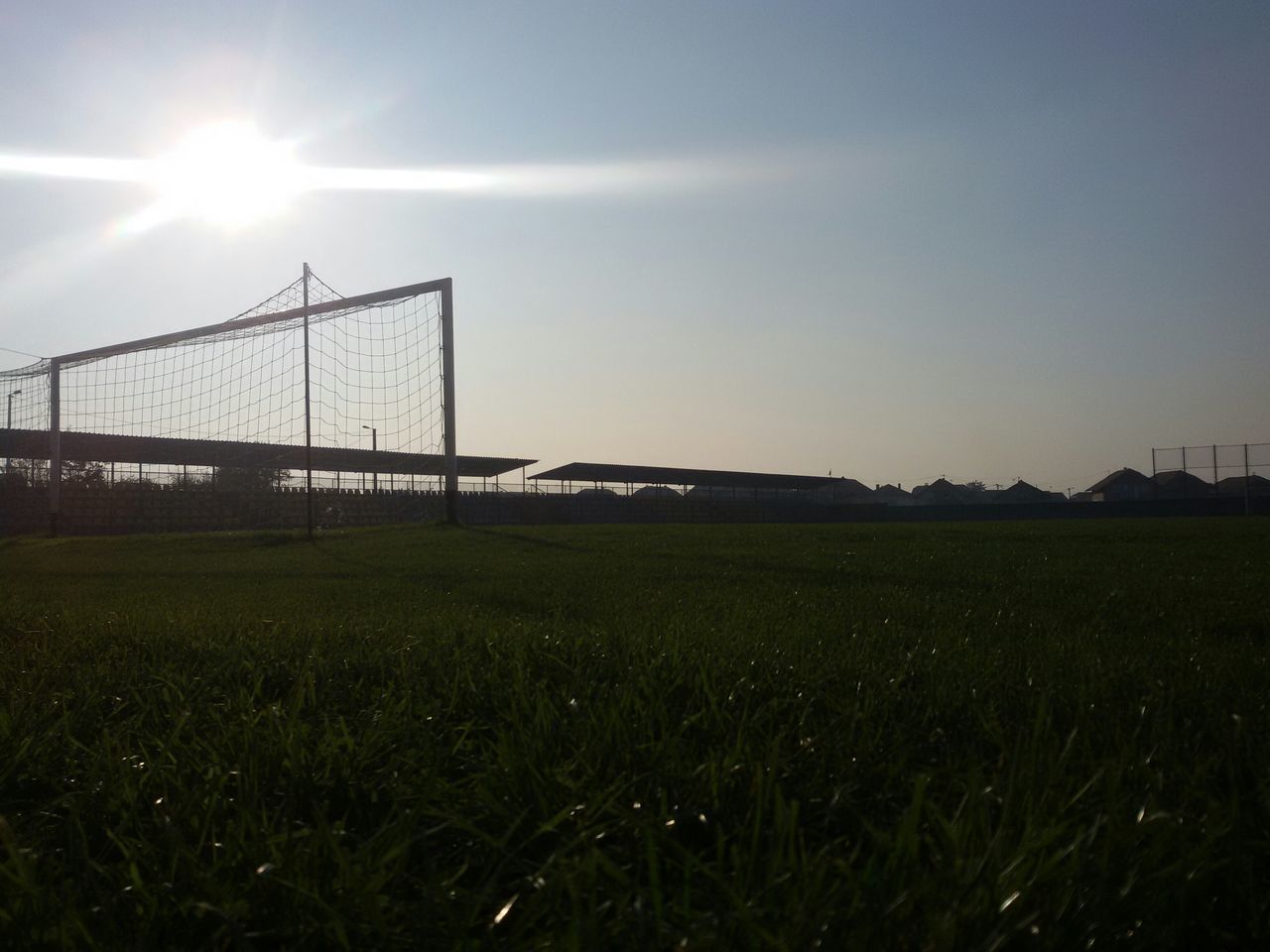 sun, grass, field, sunlight, lens flare, sunbeam, grassy, landscape, sky, built structure, clear sky, connection, architecture, bright, nature, tranquility, sunny, tranquil scene, green color, blue