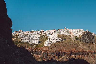 Low angle view of rock formations against clear blue sky