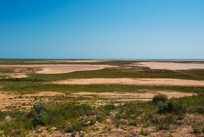 Scenic view of desert against clear blue sky