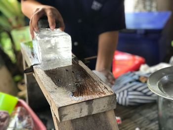 Midsection of man preparing flavored ice at market stall