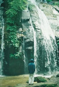 Rear view of man in waterfall