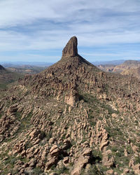 Weavers needle and rock formations on landscape against sky