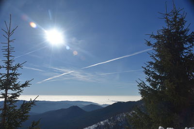 Low angle view of mountains against bright sun